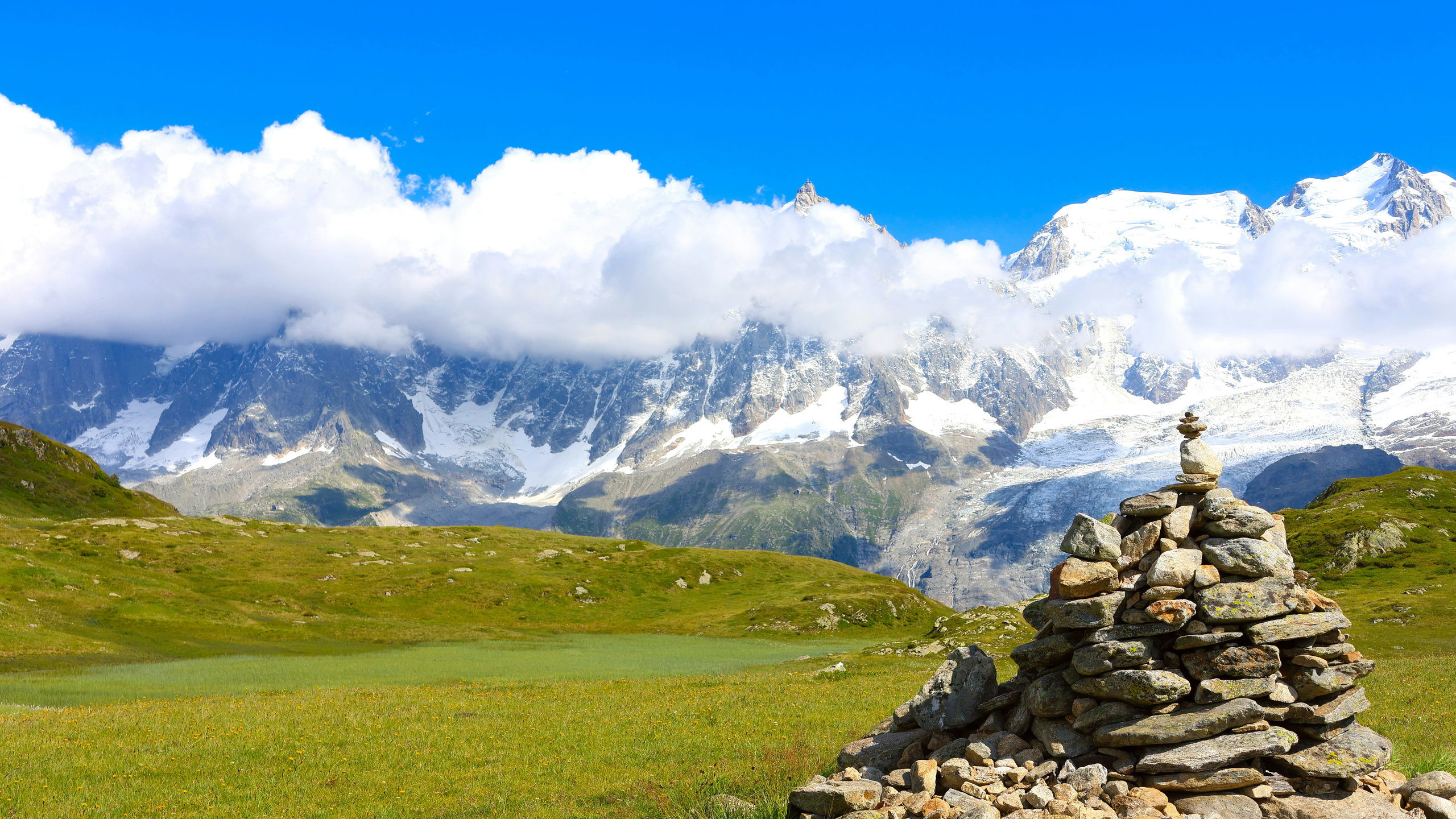 Stone cairn on the Plateau de Carlaveyron facing the snowy Mont Blanc massif, Chamonix Valley.