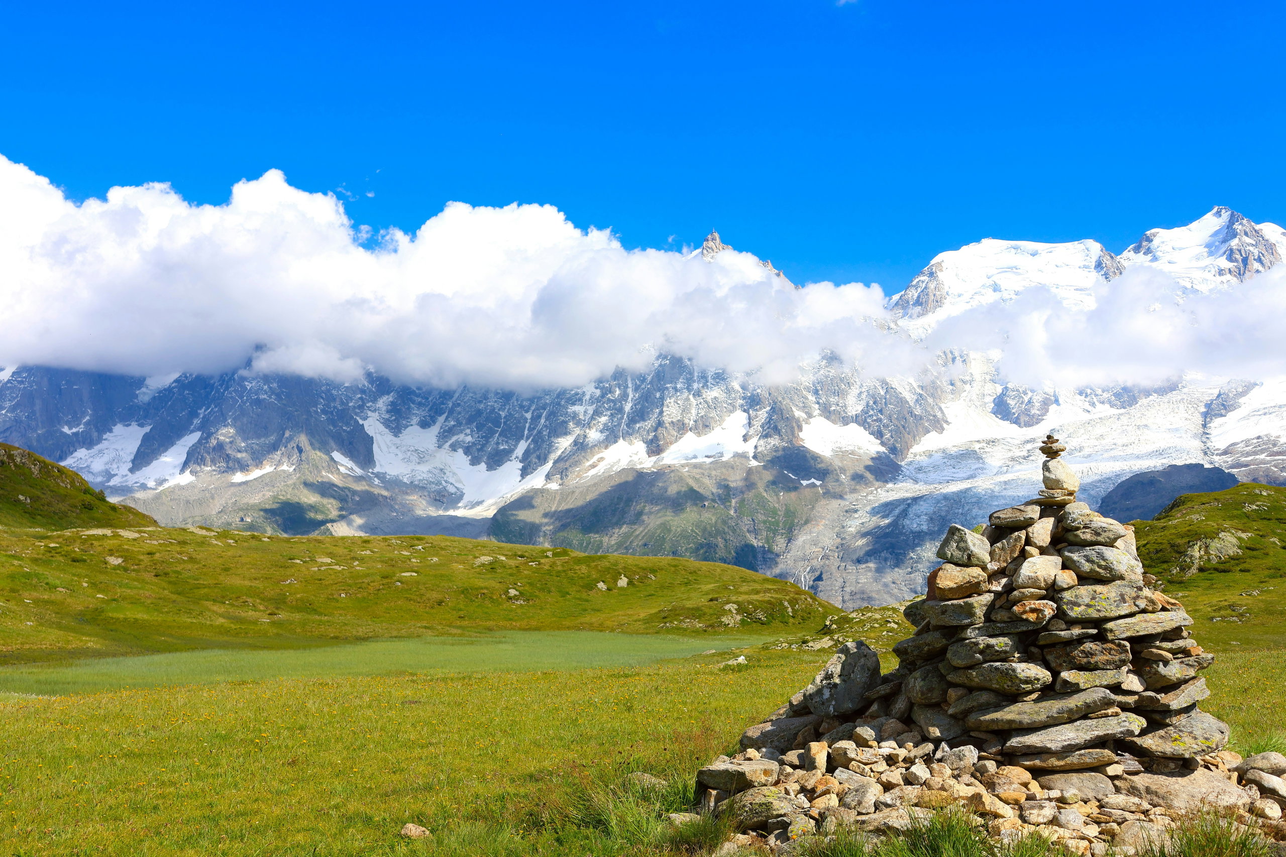 Stone cairn on the Plateau de Carlaveyron facing the snowy Mont Blanc massif, Chamonix Valley.