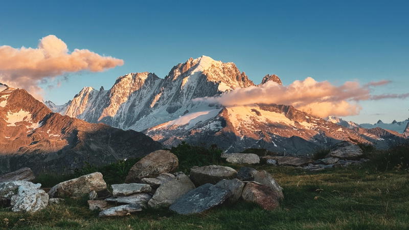 The majestic pyramid of Aiguille Verte glowing in the sunset, seen from the rocky path of the Grand Balcon Sud near Chamonix.