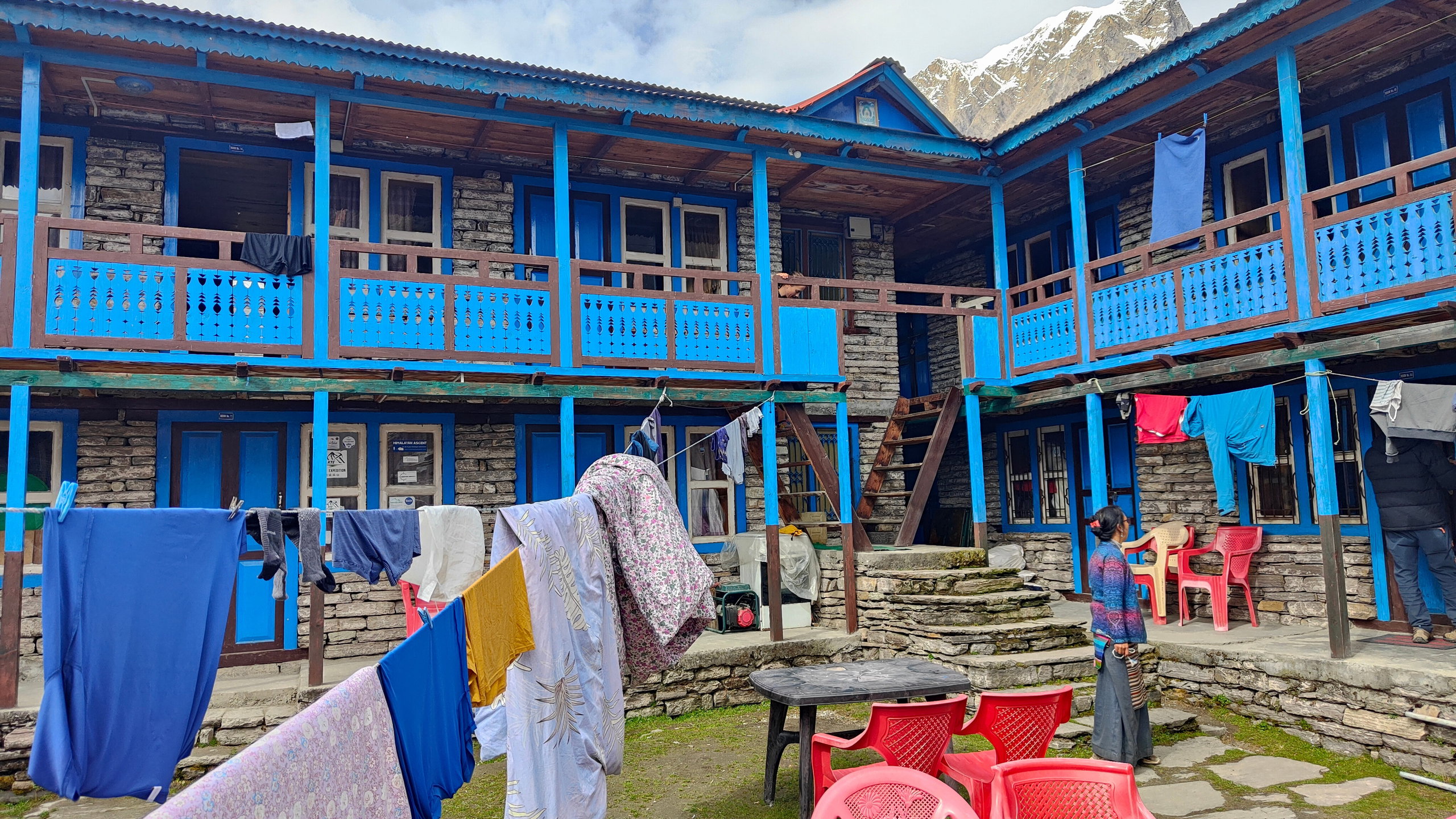 The courtyard of a blue teahouse with washing drying on lines.