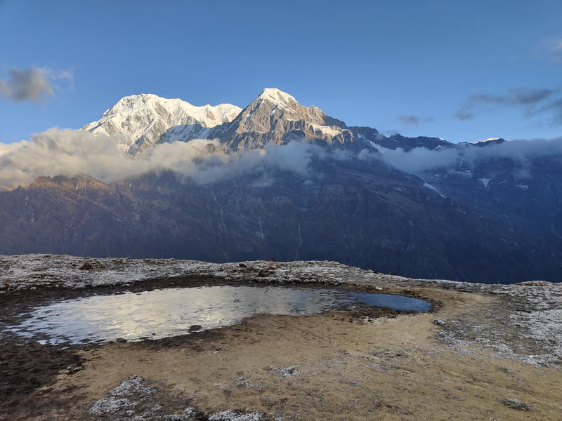 A frost-covered lake in front of Annapurna South and Hiunchuli