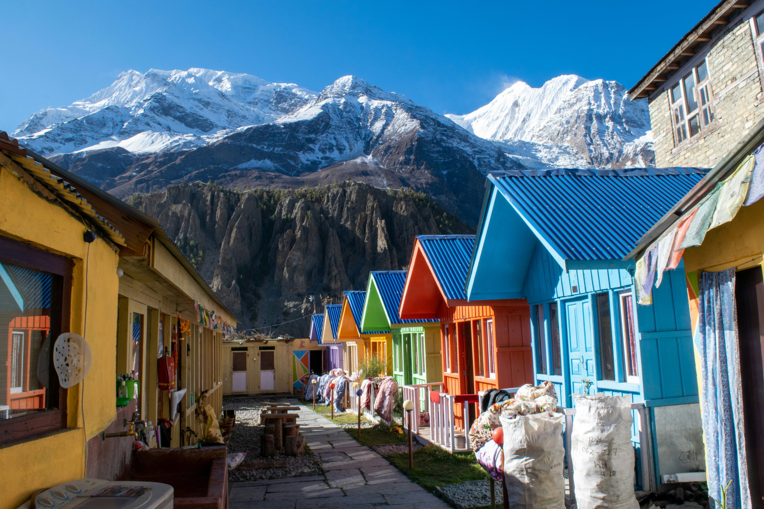 Colourful lodges in the village of Manang, with the snow-capped peaks of the Annapurnas in the background.